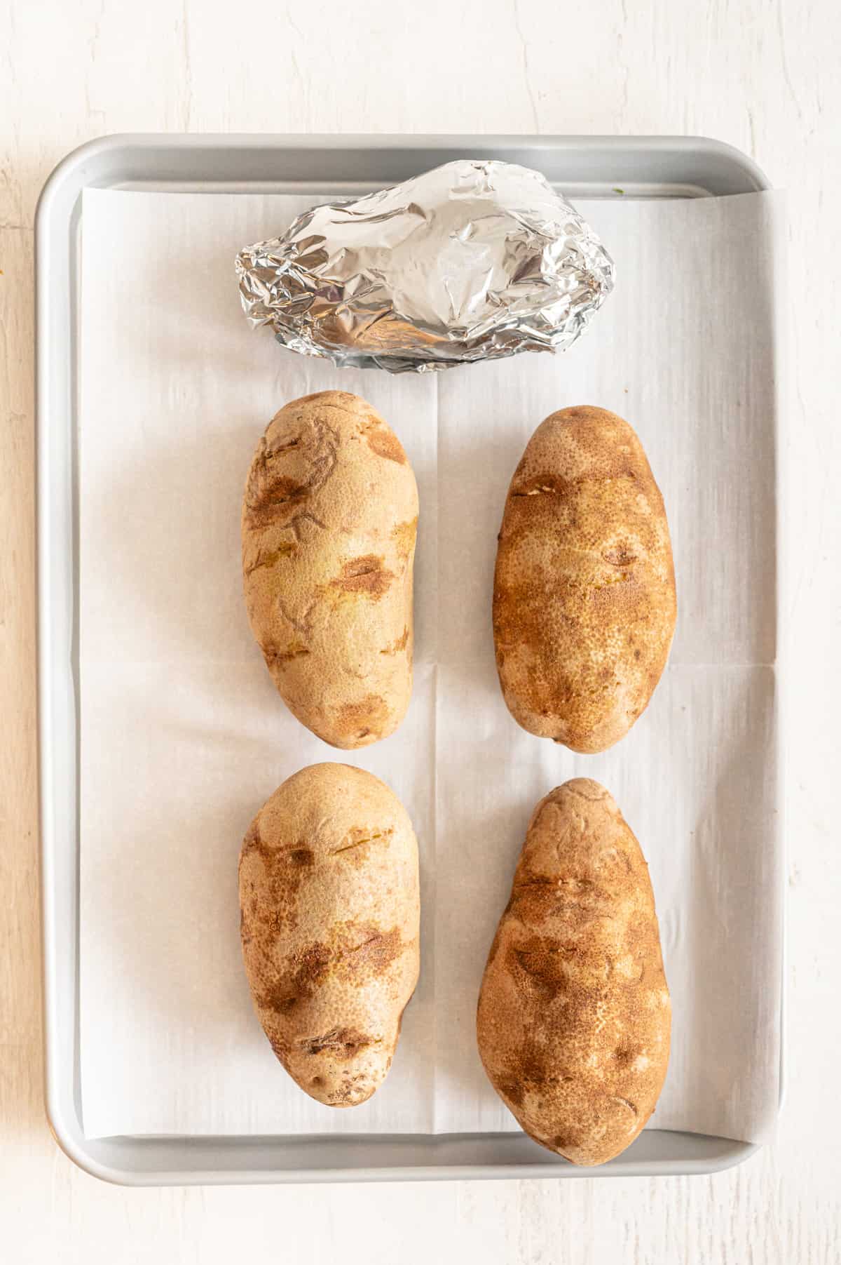 Potatoes on a baking sheet lined with parchment paper.