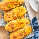 Four twice baked potatoes on a serving platter.