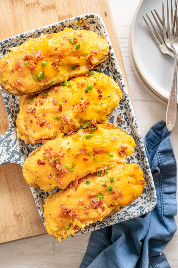 Four twice baked potatoes on a serving platter.