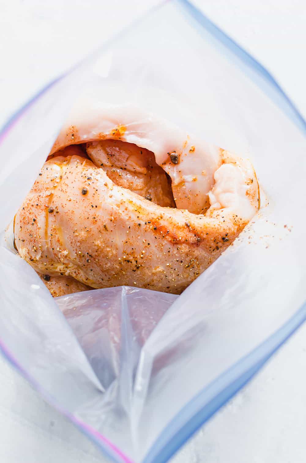 Chicken breasts marinating in a freezer bag.
