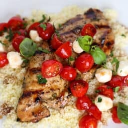 Balsamic chicken breast on top of cous cous topped with tomatoes, mozzarella, and basil.