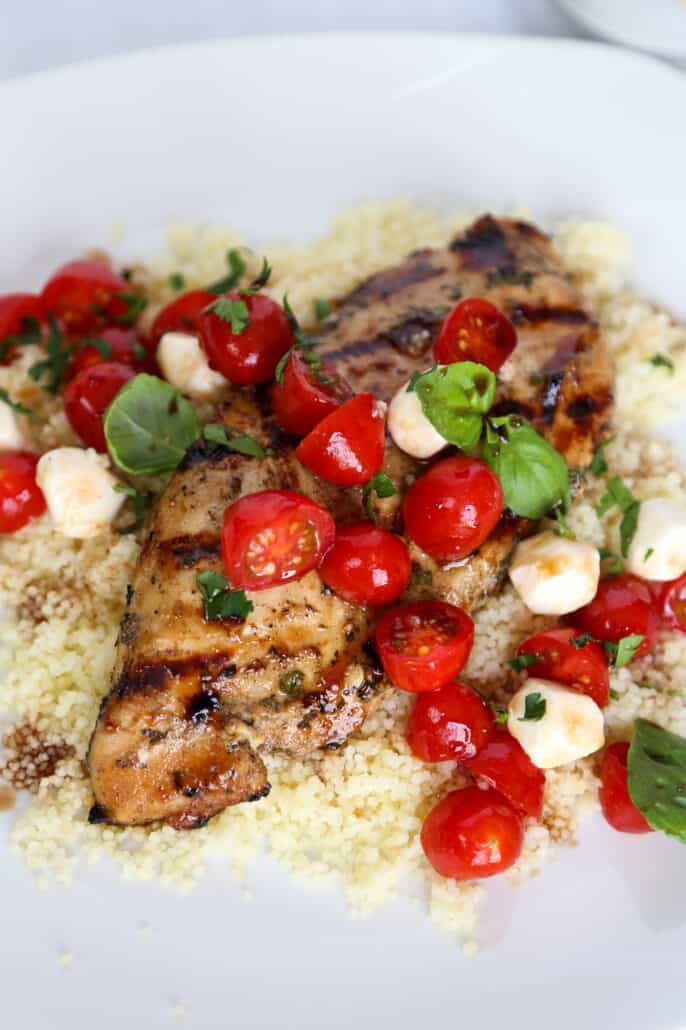 Balsamic chicken on top of quinoa topped with tomatoes and mozzarella