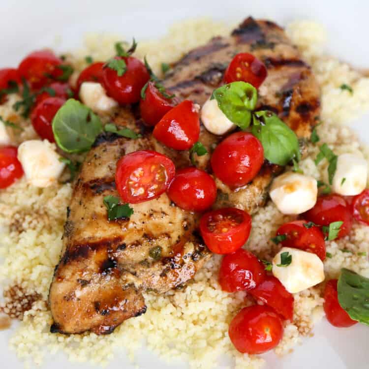 Balsamic chicken on top of quinoa topped with tomatoes and mozzarella