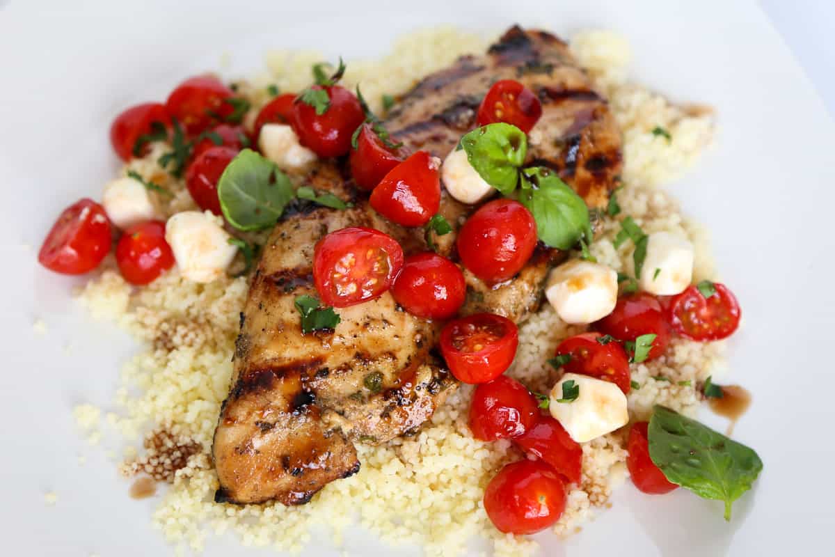 Balsamic chicken on top of quinoa topped with tomatoes and mozzarella.