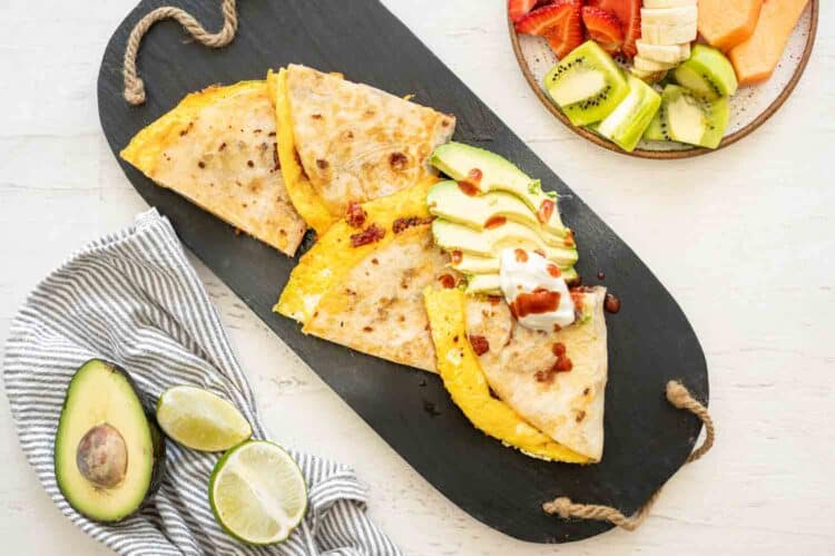 breakfast quesadilla cut up on a wooden cutting board