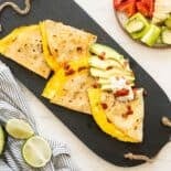 Cut up Breakfast Quesadilla with sliced avocado on a serving tray.
