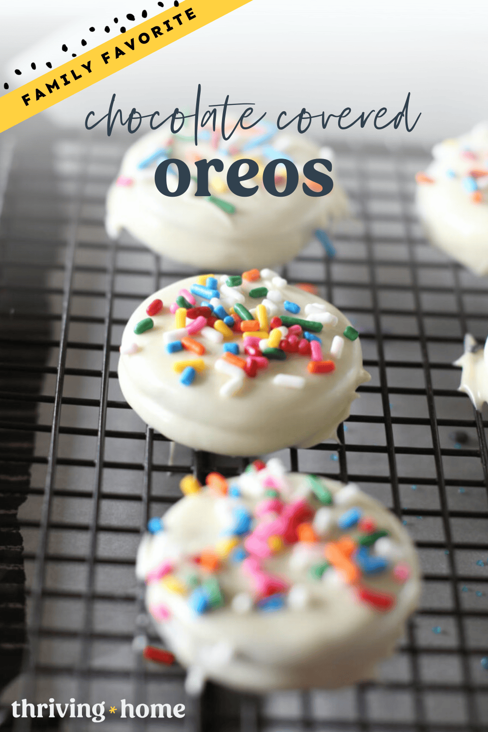 White chocolate covered Oreos with sprinkles on top on a cooling rack.