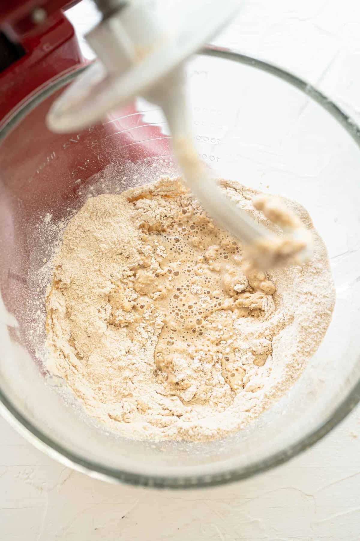 flour added to wet ingredients in a stand mixer bowl