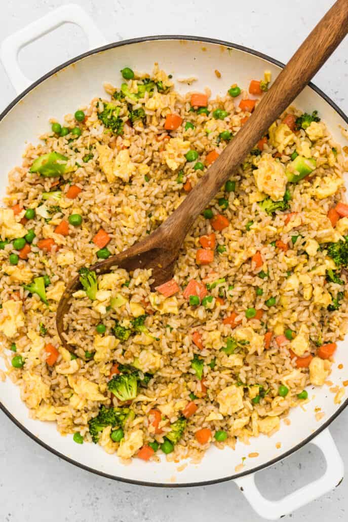 skillet of egg fried rice with wooden spoon