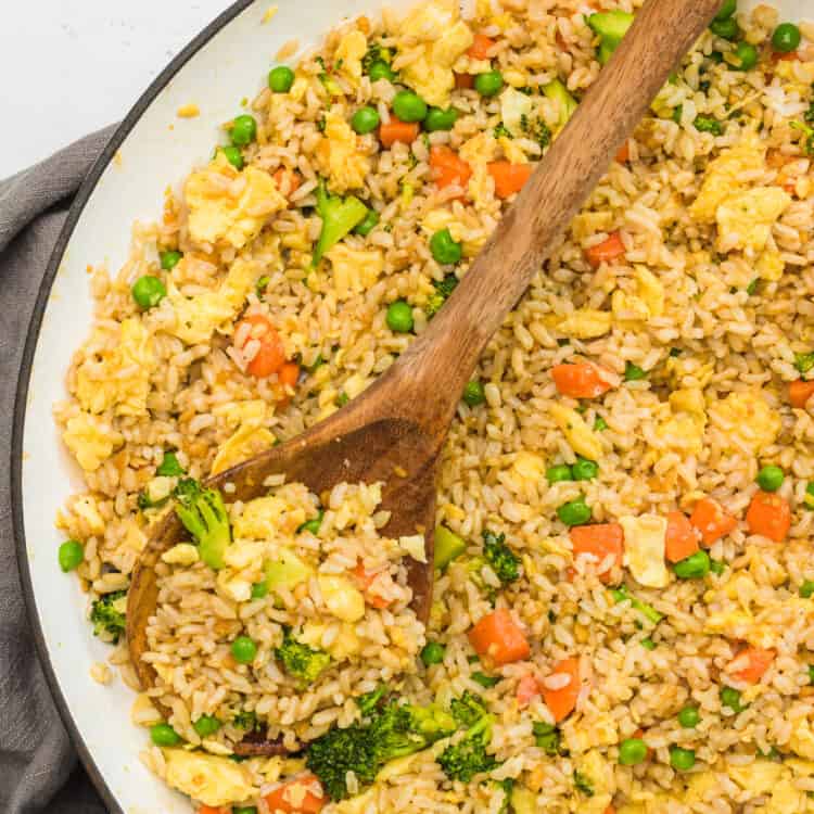 skillet of eegg fried rice with wooden spoon