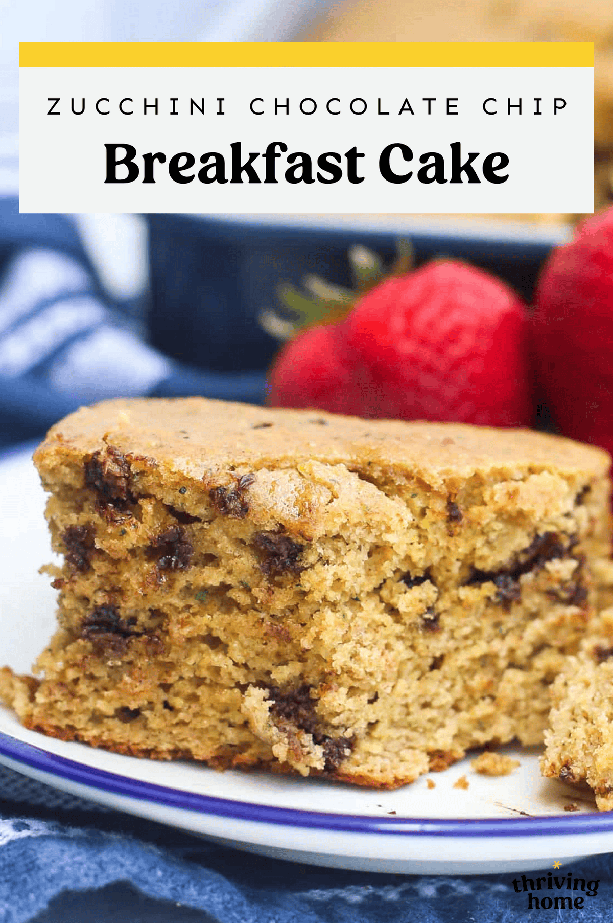 A serving of zucchini breakfast cake on a plate with whole strawberries.