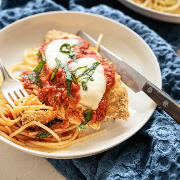 Baked Chicken Parmesan on plate with whole wheat noodles