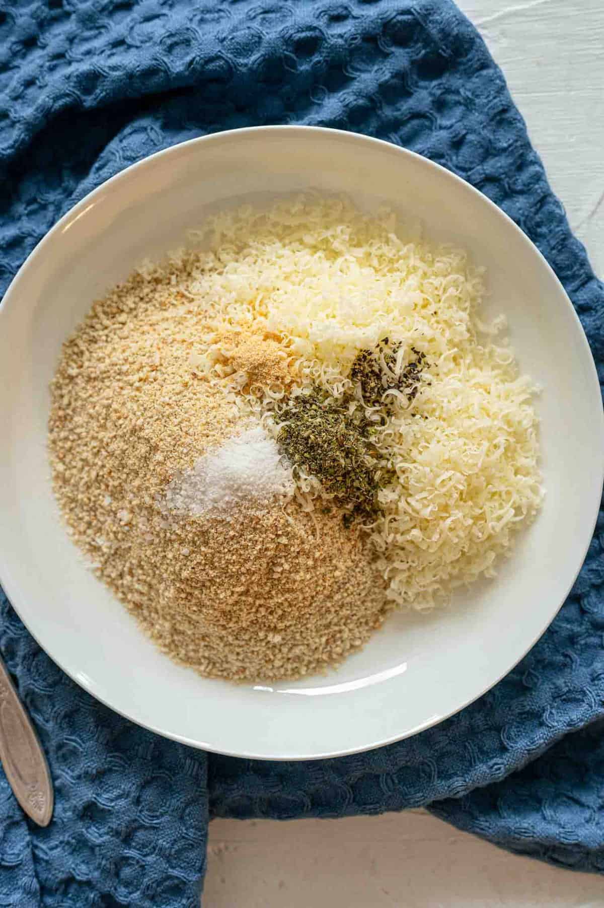 Bread crumbs, seasonings, and grated parmesan cheese in bowl for breading chicken breasts.