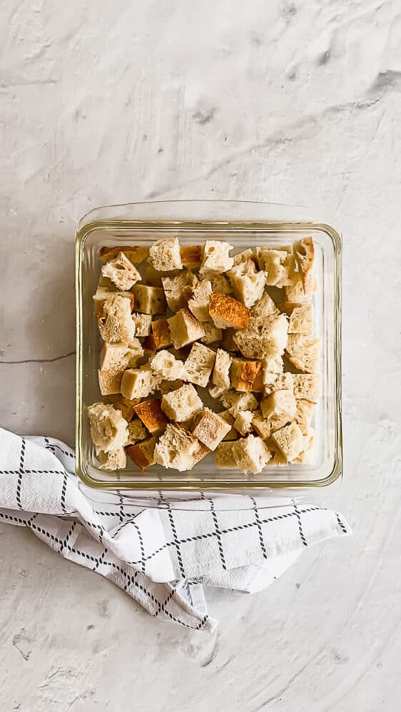 cubed bread pieces in a glass casserole dish