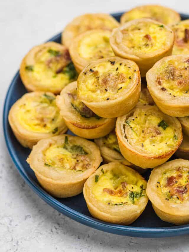 Baked Bacon and Spinach Mini Quiche stacked up on a plate.