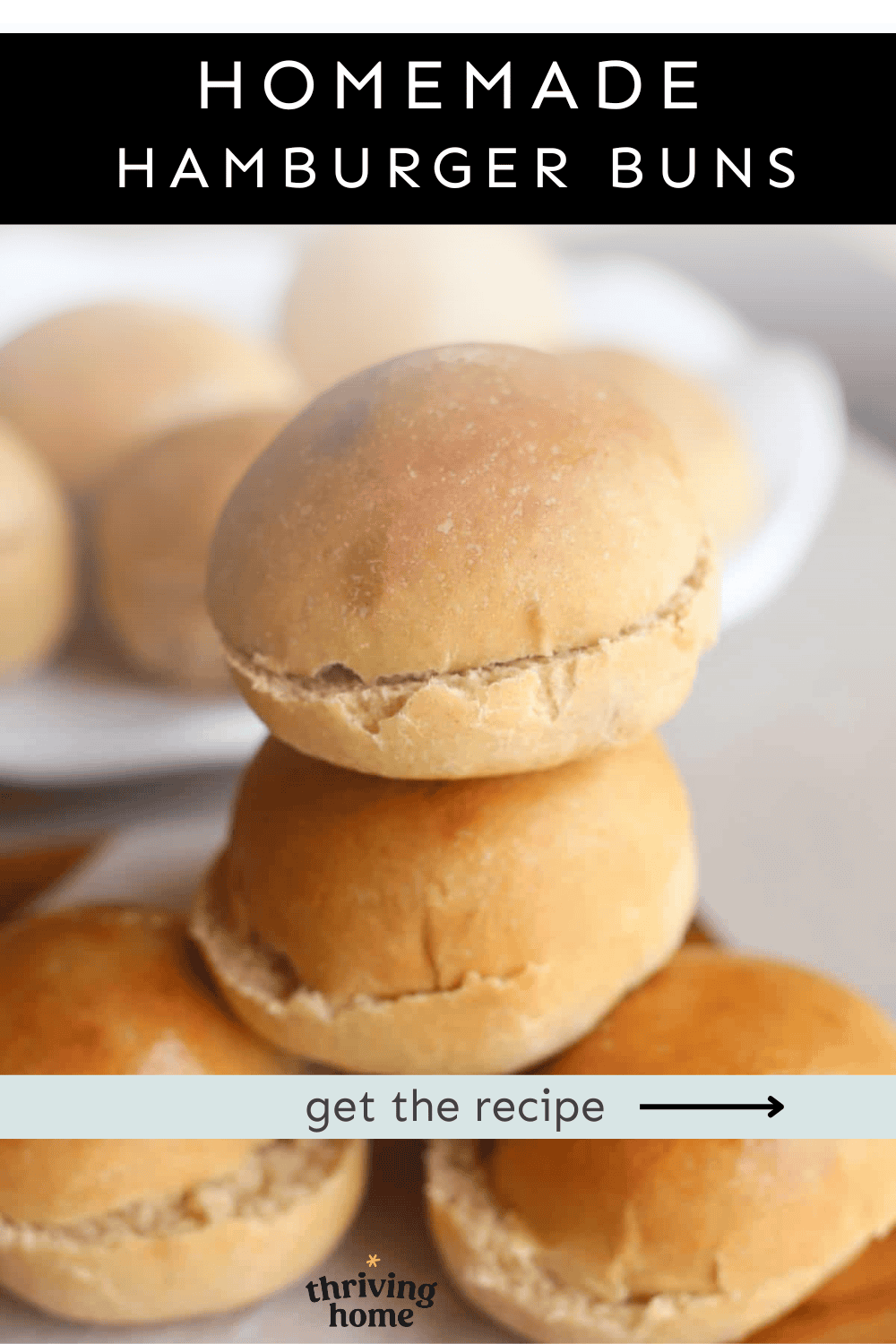 Two homemade hamburger buns stacked on top of each other on a plate.