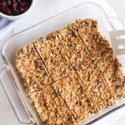 Homemade peanut butter protein bars in a glass dish sliced and ready to be wrapped individually.