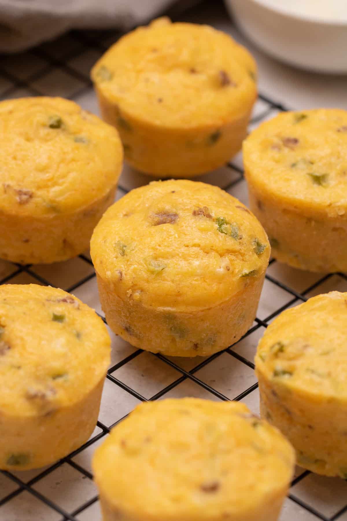 Savory Breakfast Muffins resting on a cooling rack before being served.