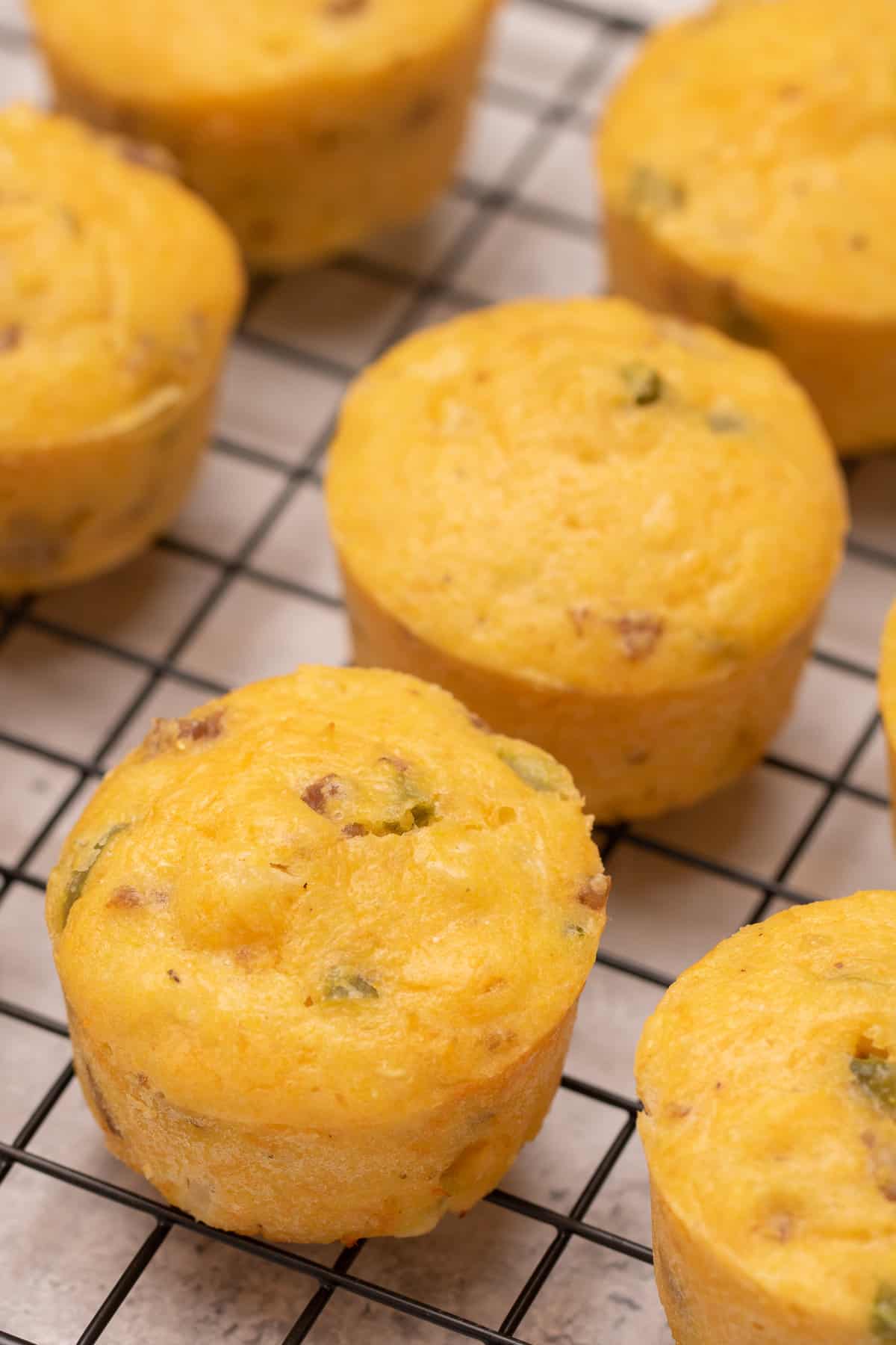 Savory Breakfast Muffins resting on a cooling rack before being served.