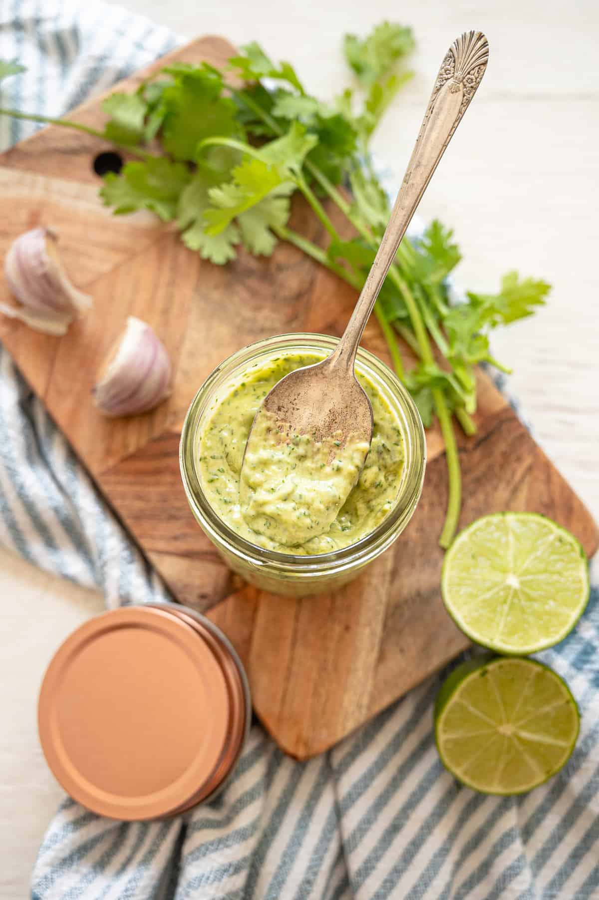 Cilantro Lime Aioli in a small mason jar with a spoon dipped in.