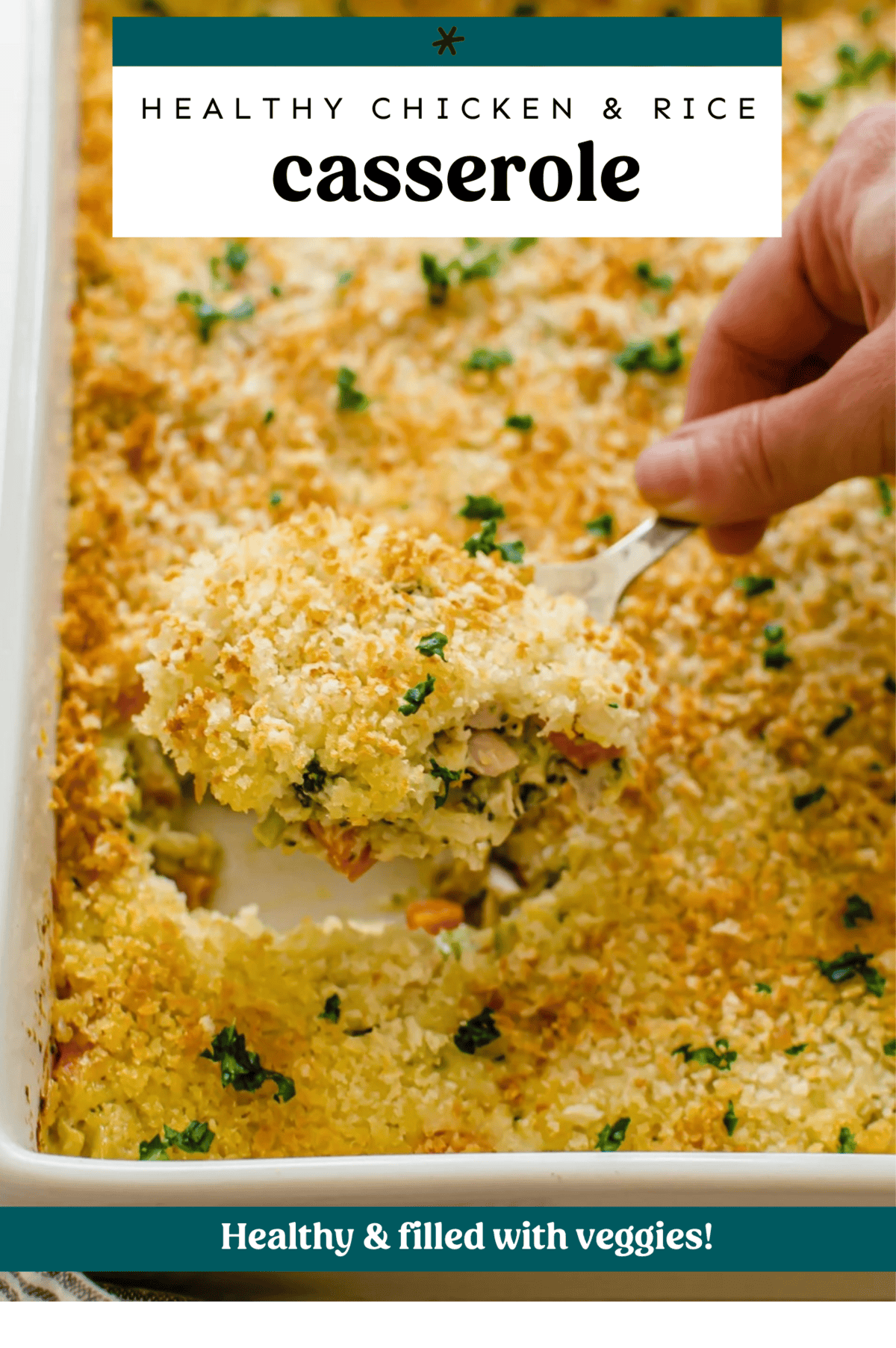 Cheesy chicken and rice casserole being dished out of a white baking dish.