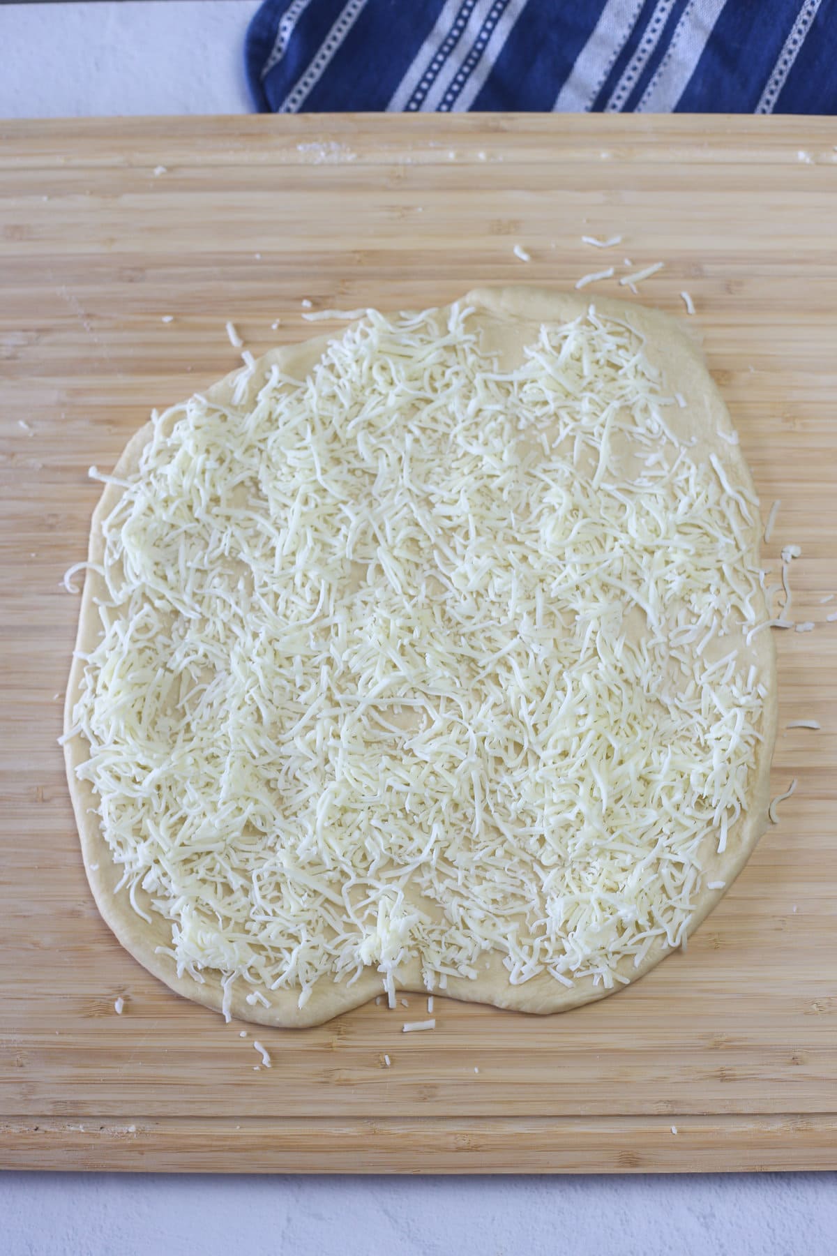 Shredded cheese on top of rolled out dough.