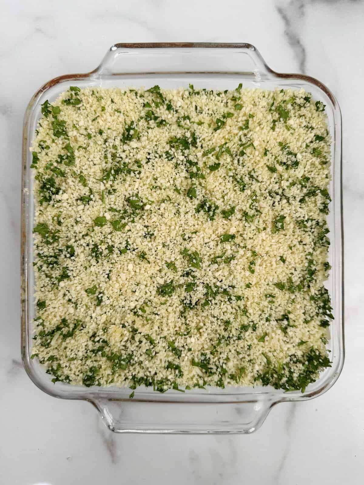 Seasoned breadcrumb mixture with fresh chopped parsley on top of the chicken parmesan casserole.
