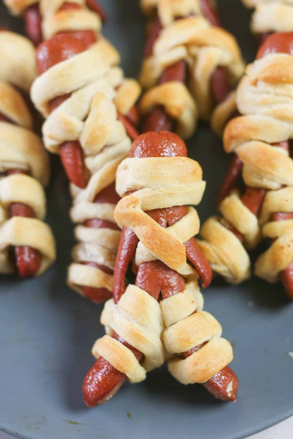 Mummy hot dogs on a plate.