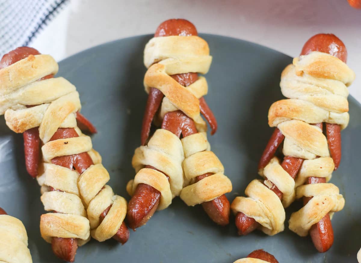 3 Mummy hot dogs on a plate. 