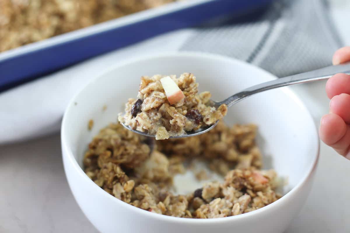 A spoon scooping a bite of apple cinnamon baked oatmeal. 