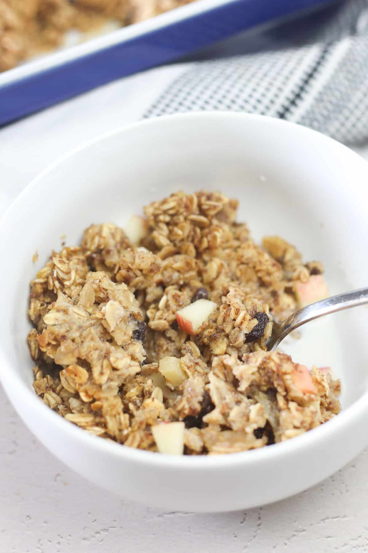 Apple cinnamon baked oatmeal in a white bowl. 