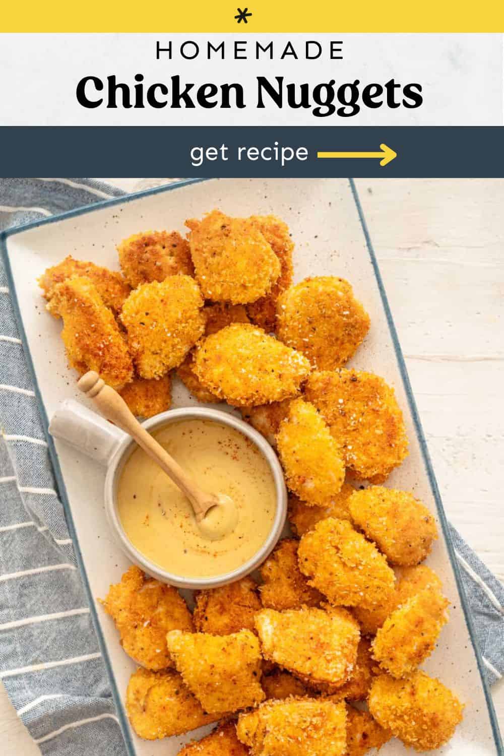 Homemade chicken nuggets on a platter served with a bowl of honey mustard.