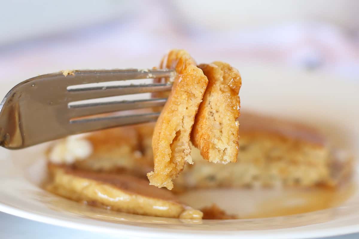 A fork with a bite of oatmeal pancakes on it.