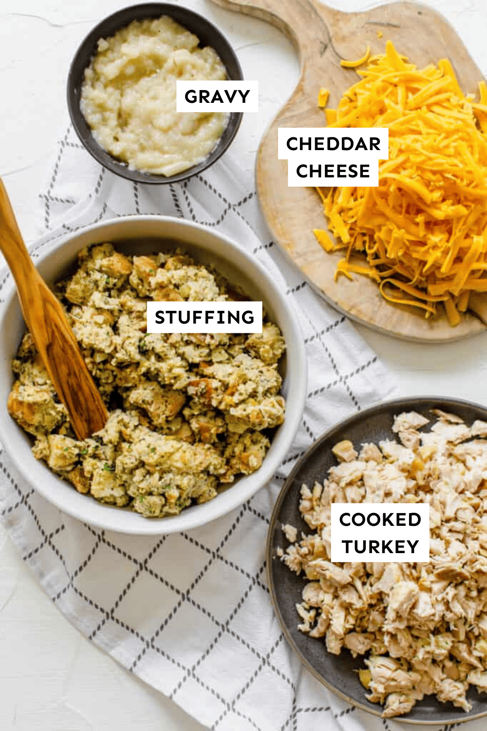 Turkey stuffing casserole ingredients (chopped turkey, gravy, cheddar cheese, and stuffing) measured into bowls and labeled.