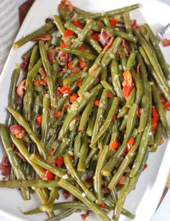 Skillet green beans with red bell pepper and onions on a platter.