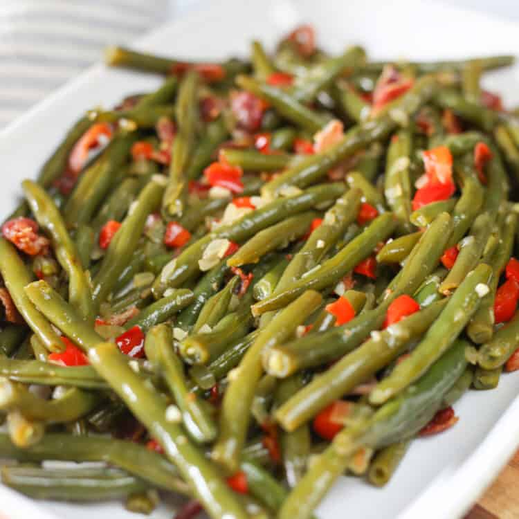 Skillet green beans with red bell pepper and onions on a platter.