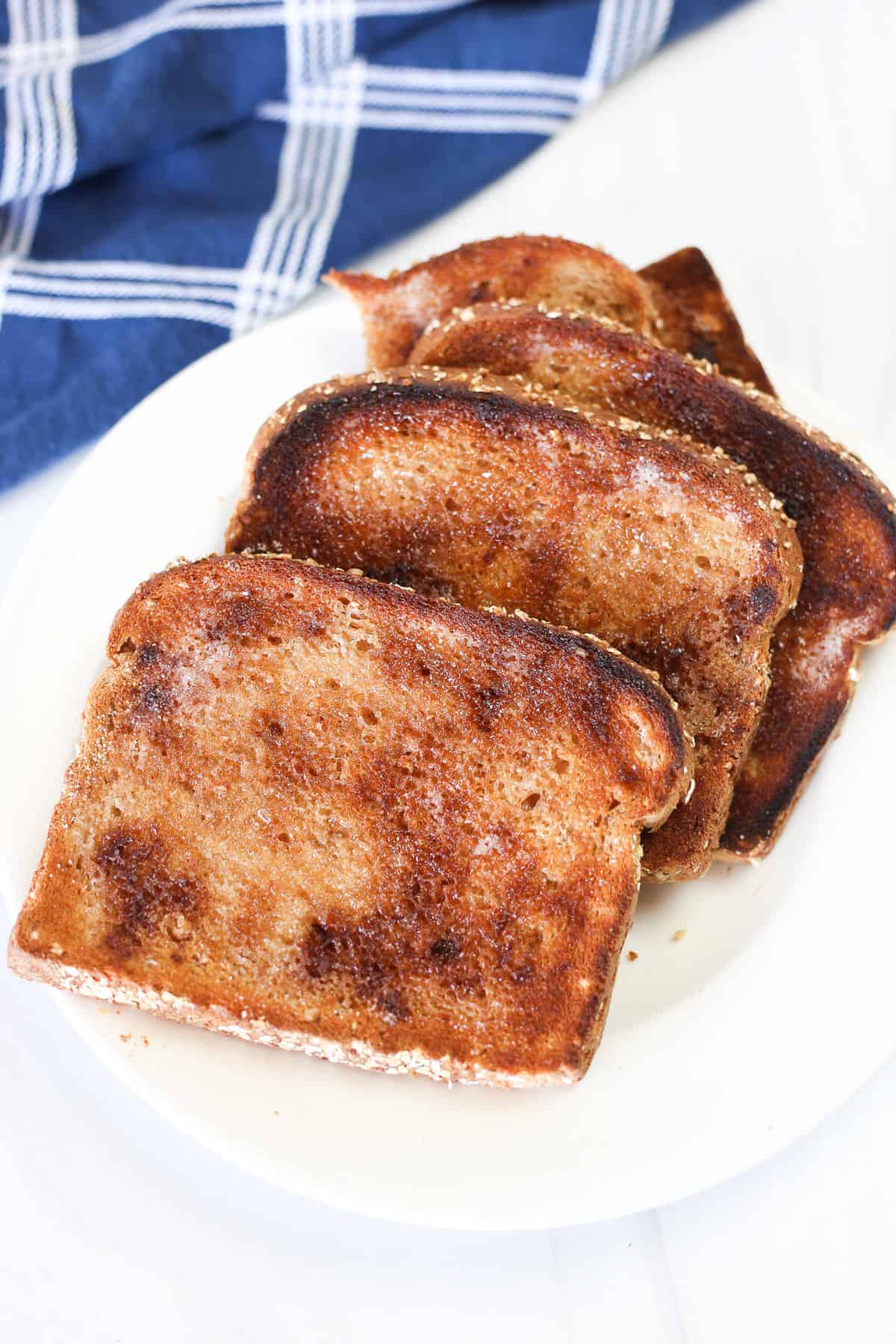 A stack of cinnamon toast that's been cooked in the oven on a plate. 