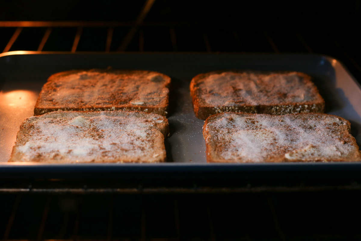 Prepared cinnamon toast on a baking sheet in the oven. 
