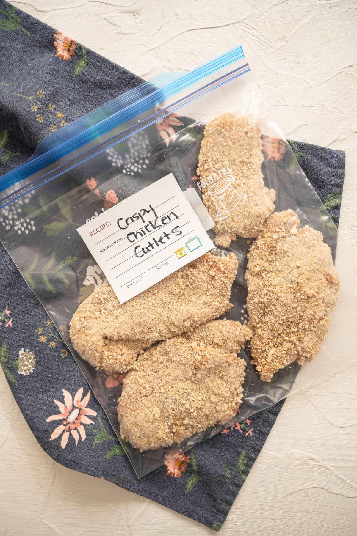 Uncooked breaded chicken cutlets in a freezer bag labeled Crispy Chicken Cutlets.