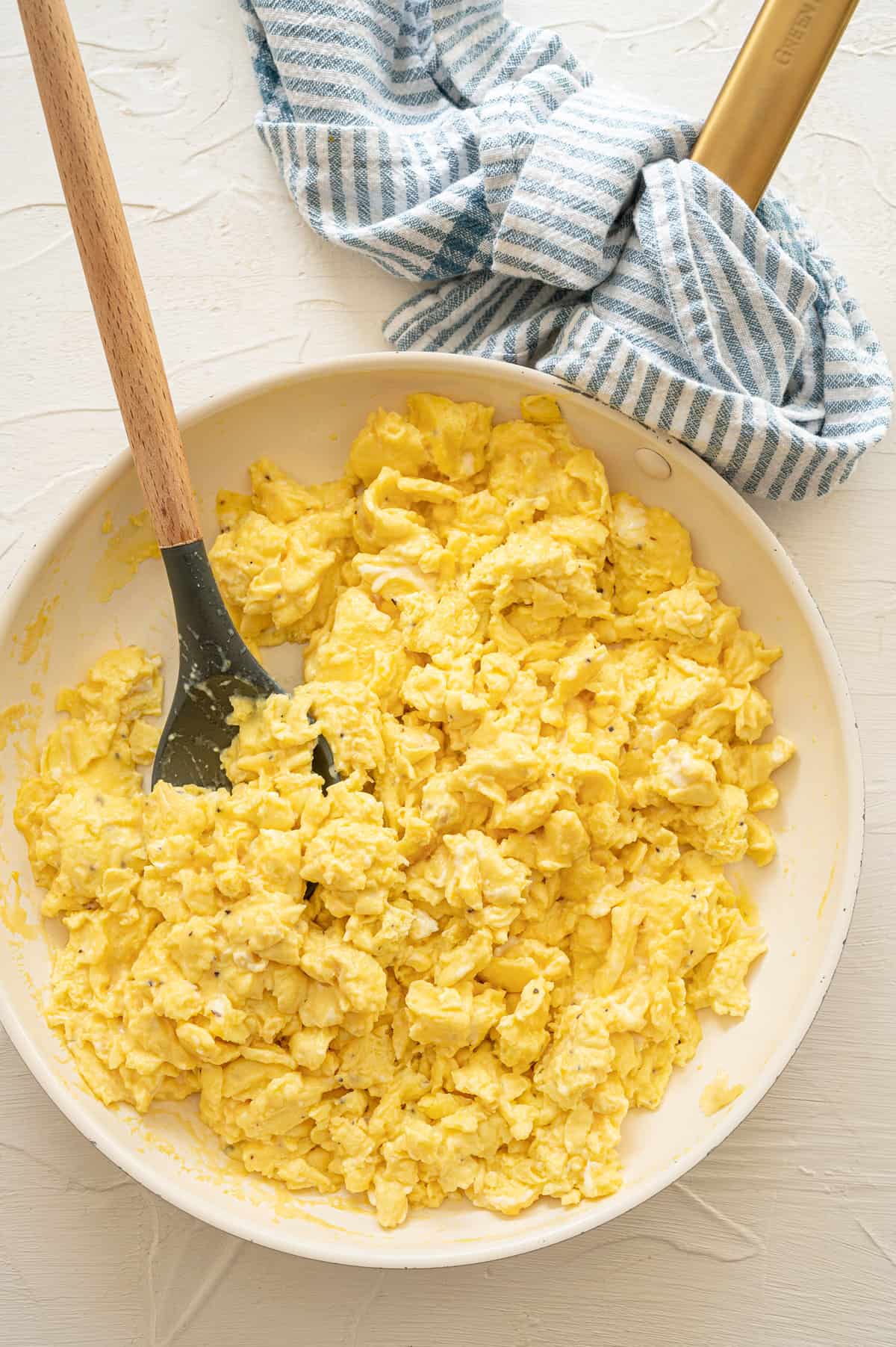 Scrambled eggs in a white mixing bowl.