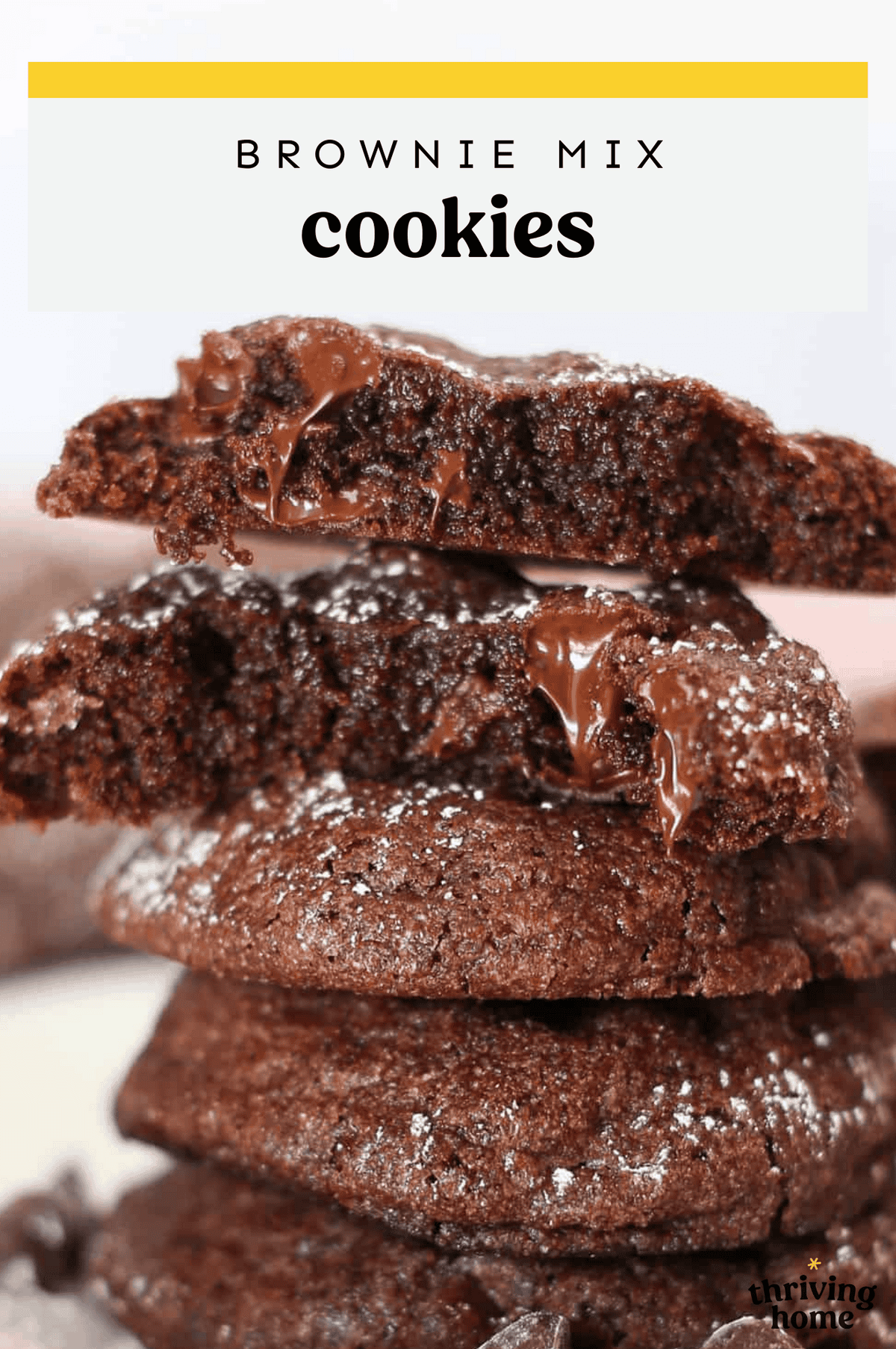 Brownie  mix cookies stacked up on parchment paper.