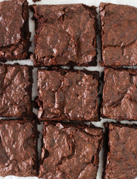 Brownies cut in squares on parchment paper.