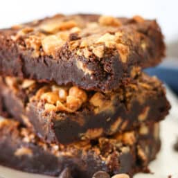 3 peanut butter swirl brownies stacked up on a plate.