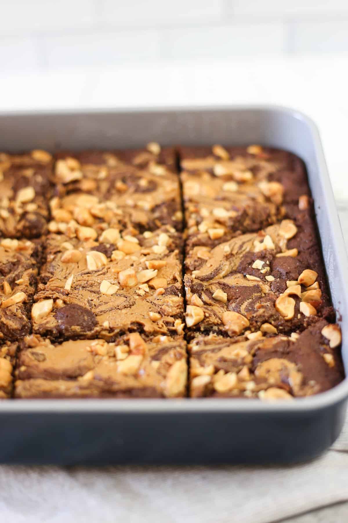 Peanut Butter Swirl Brownies fully cooked and sliced in a 9x9 metal baking pan.