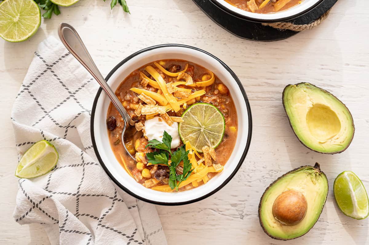 Bowl of vegetarian tortilla soup with lots of toppings.