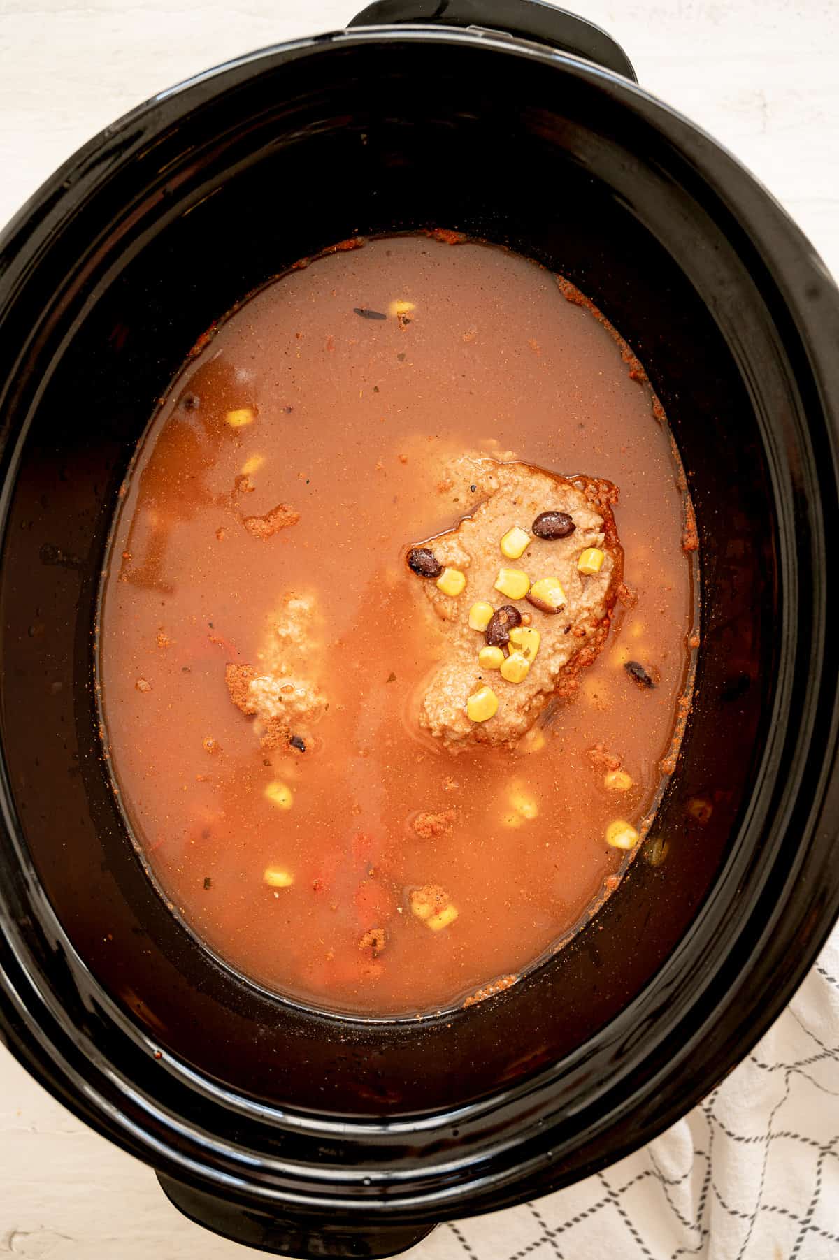 Crockpot vegetarian tortilla soup ingredients dumped in a slow cooker.