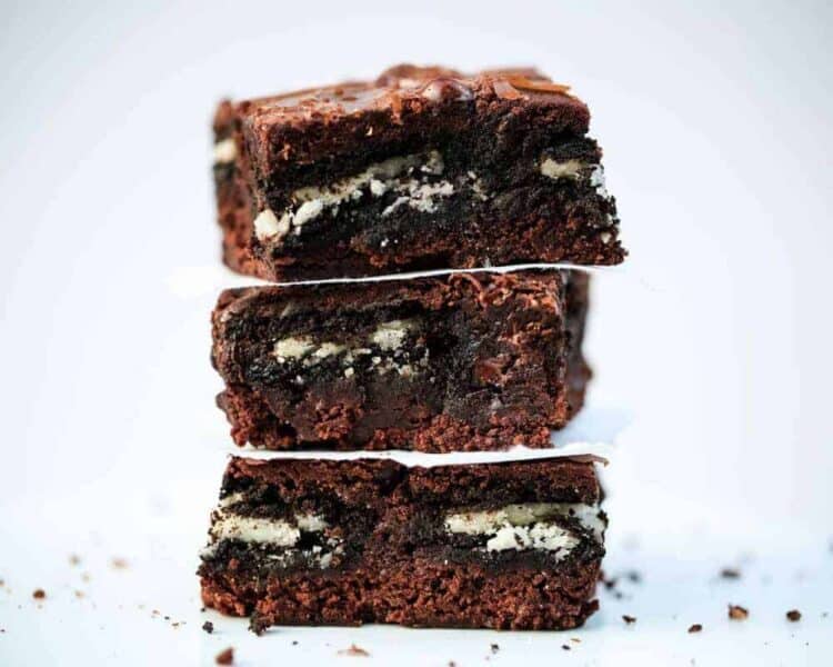 Three Oreo brownies stacked up on a plate.
