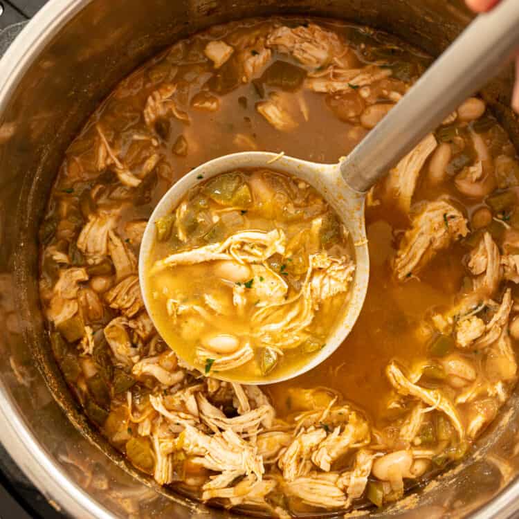 A ladle of white chicken chili being served out of an instant pot.