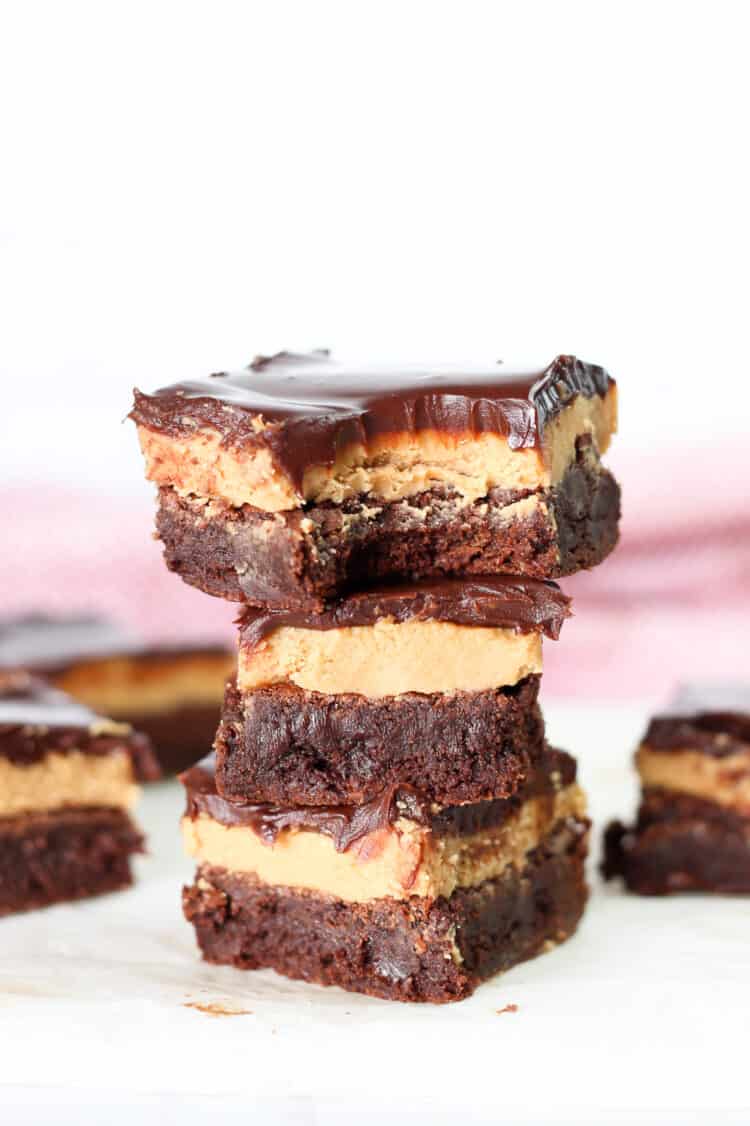 Three buckeye brownies stacked on top of each other and the top one with a bite out of it.