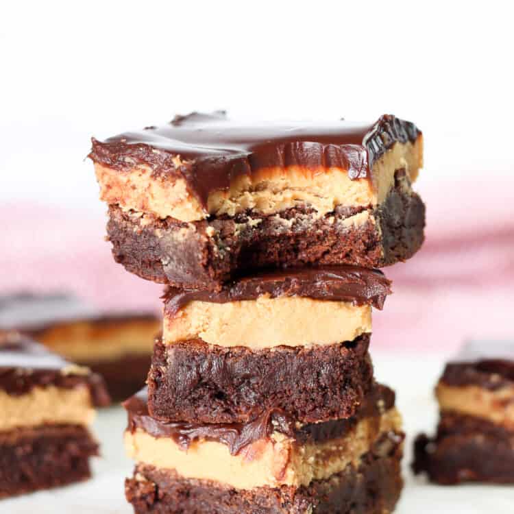 Three buckeye brownies stacked on top of each other and the top one with a bite out of it.